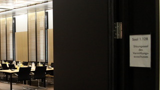 Foto: Blick in den Sitzungssaal des Vermittlungsausschusses mit Hinweisschild zum Saal 