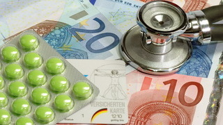 Foto: Eurobanknoten mit Stethoskop und Tabletten