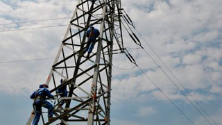 Foto: Arbeiter auf einem Strommast