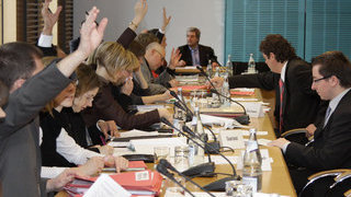 Foto: Mitglieder des Ausschusses heben ihre Hand zur Abstimmung