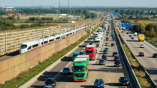 Foto: Autobahn und parallel verlaufender Eisenbahn mit Autos und Bahn