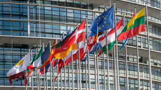 Foto: Flaggen der EU wehend vor dem Gebäude der Europäischen Union