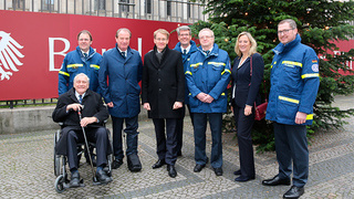 Foto: Gruppenbild mit Vertretern des THW vor Weihnachtsbaum