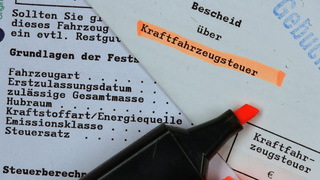 Foto: Markierungsstift liegt auf einem Bescheid über Kraftfahrzeugsteuer