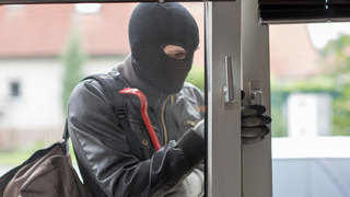 Foto: maskierter Einbrecher am Fenster