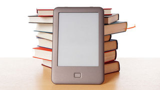 Foto:  E-Book vor einem Bücherstapel