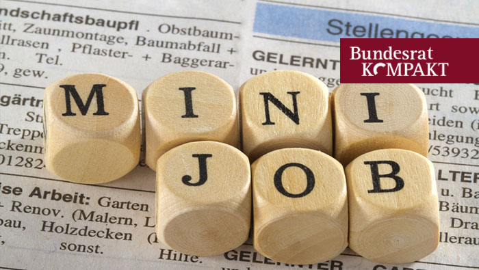 Foto: Mehrere Buchstabenwürfel zum Wort Minijob auf Zeitungsauschnitt Stellenangebote liegend